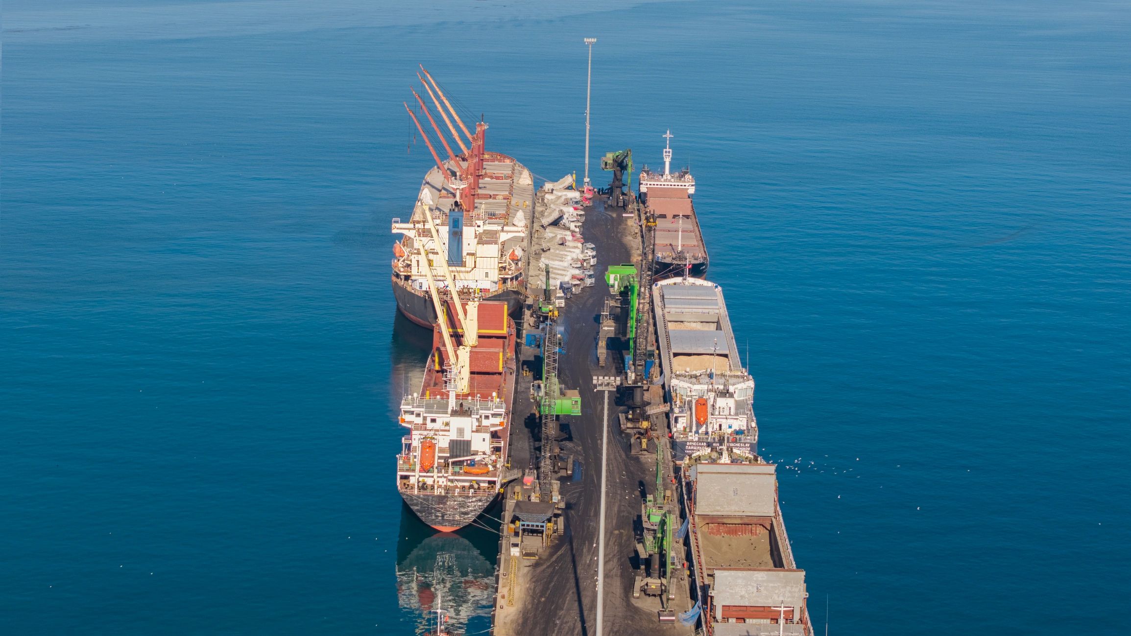 Aerial view of cargo ships and cranes at a busy industrial port