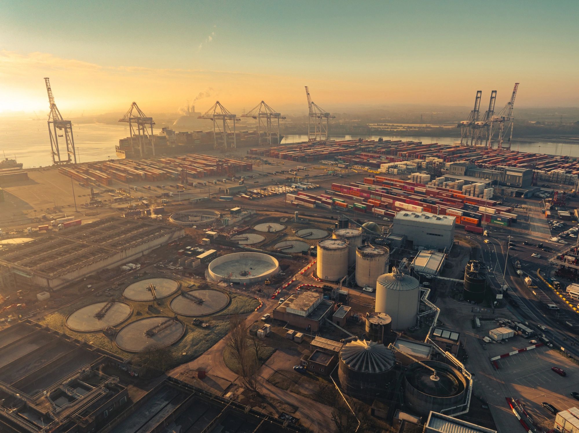 Southampton port container terminal with industrial plant at sunset