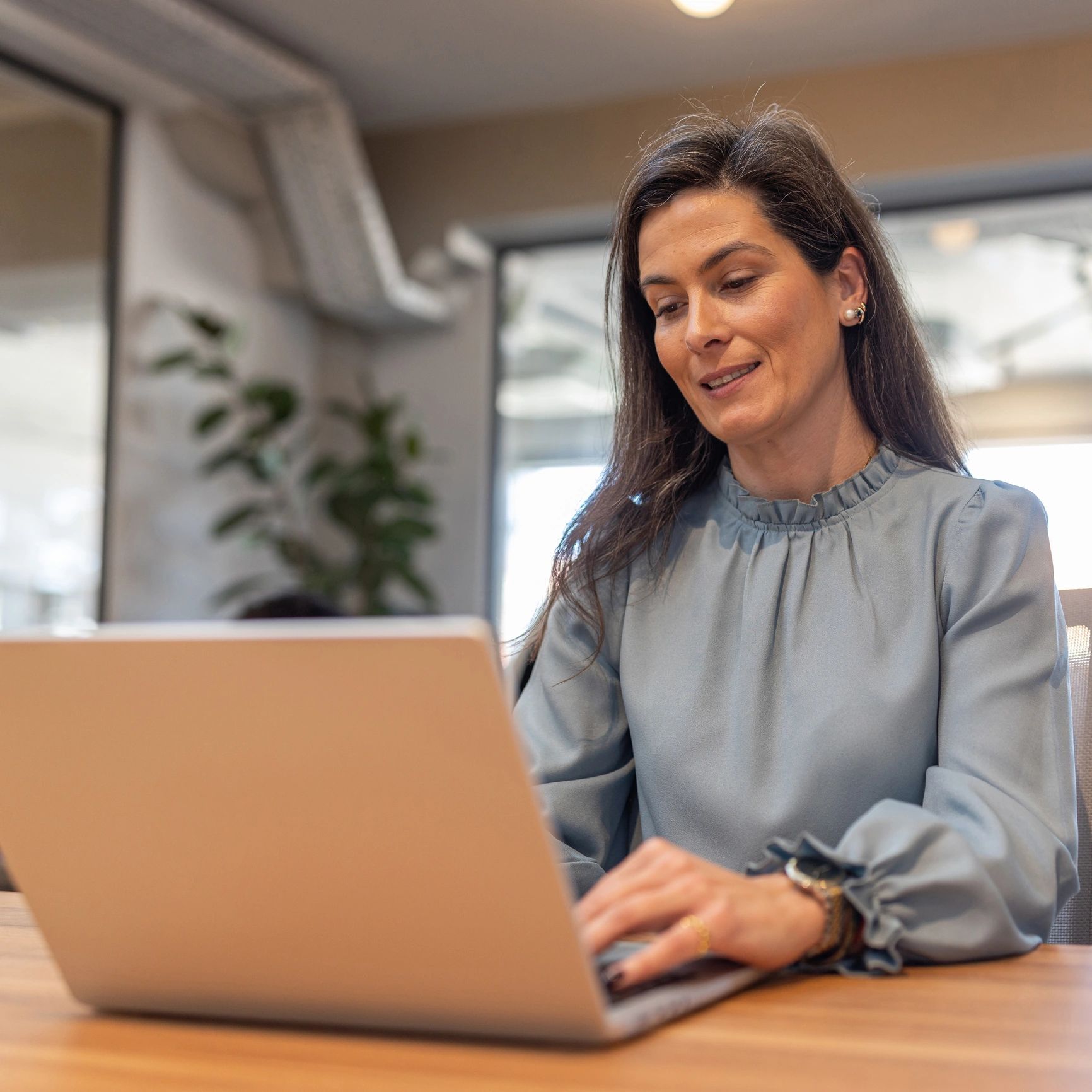 Professional staff member handling electronic document submission on a laptop
